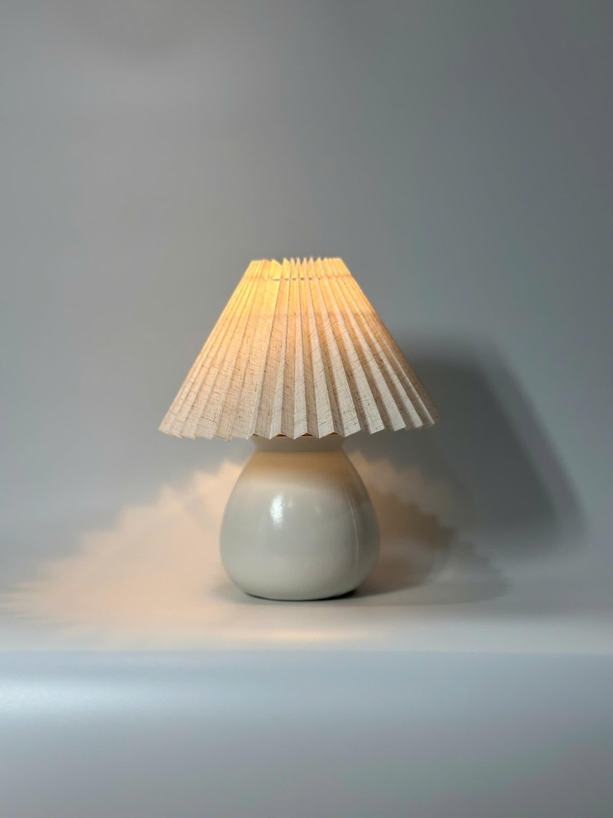 Handmade ceramic table lamp with warm ambient light. Simple form, gentle glow, timeless mood.