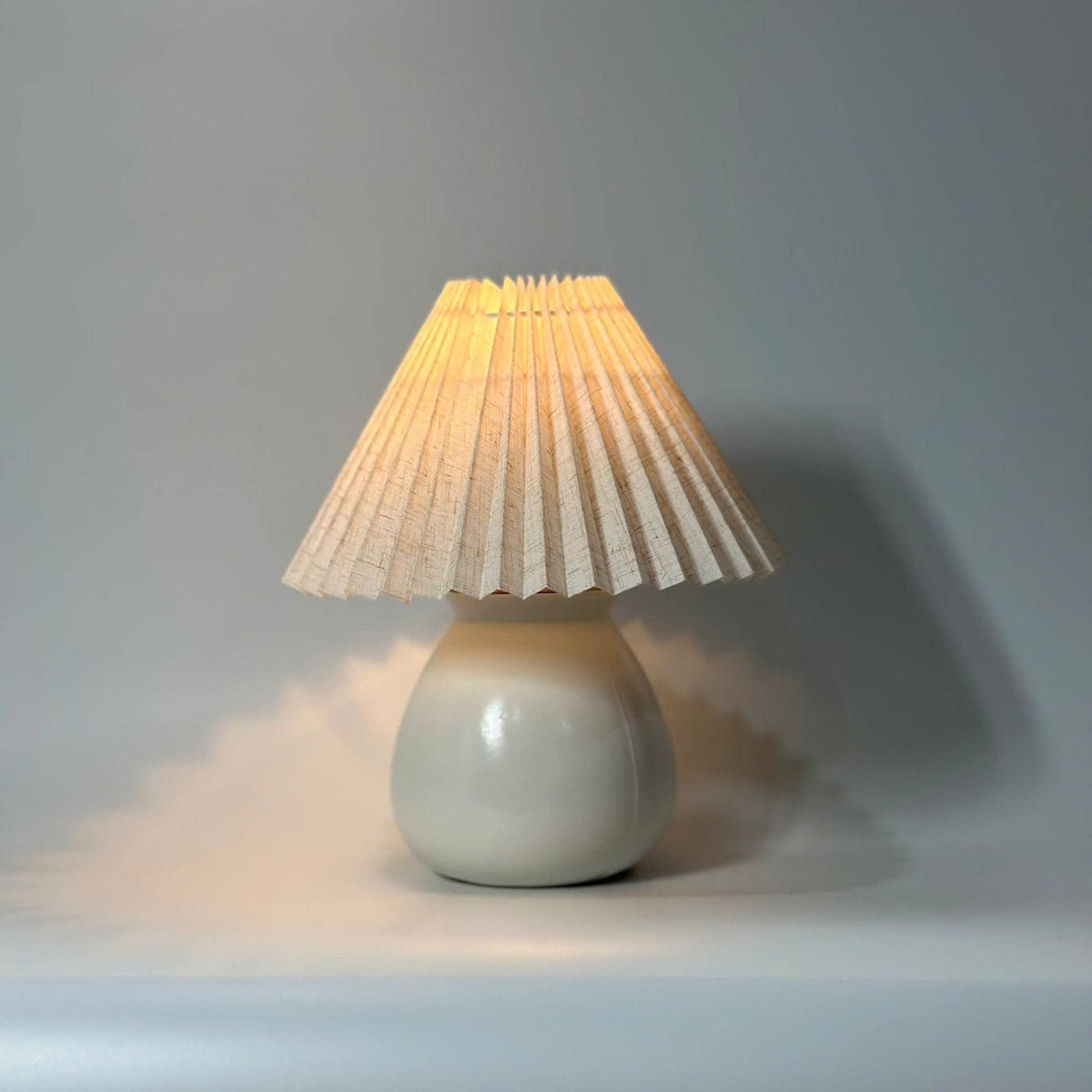 Handmade ceramic table lamp with warm ambient light. Simple form, gentle glow, timeless mood.