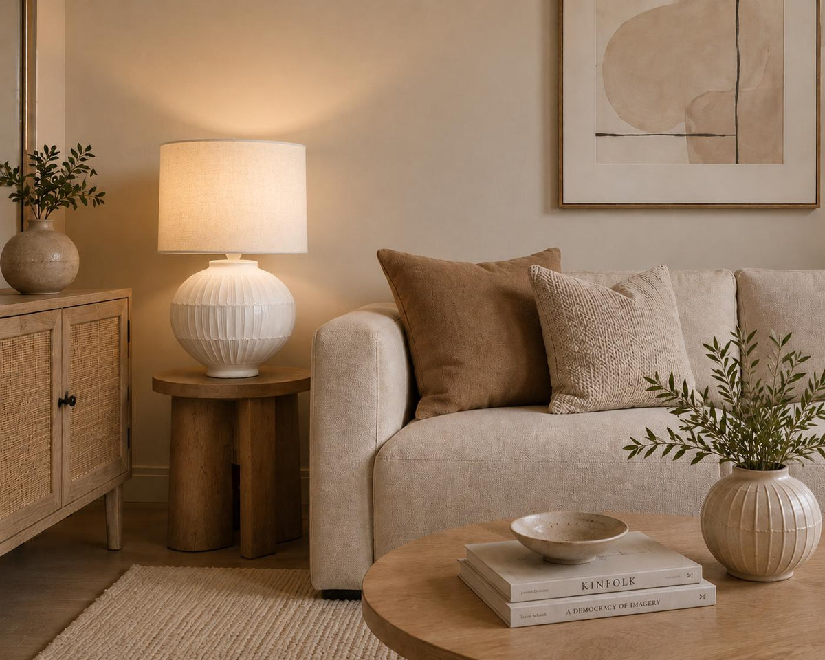 Handmade ceramic table lamp with a hand-painted ceramic body and soft fabric shade, casting a warm wabi-sabi glow.