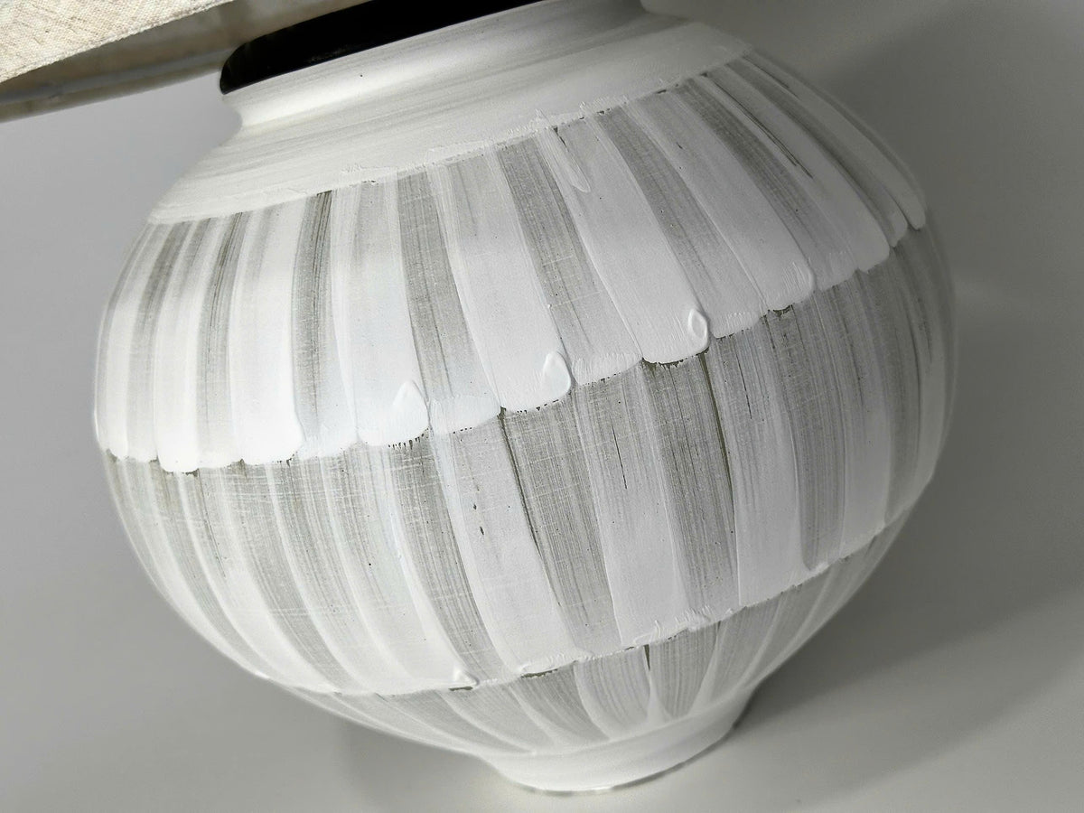 Handmade ceramic table lamp with a hand-painted ceramic body and soft fabric shade, casting a warm wabi-sabi glow.