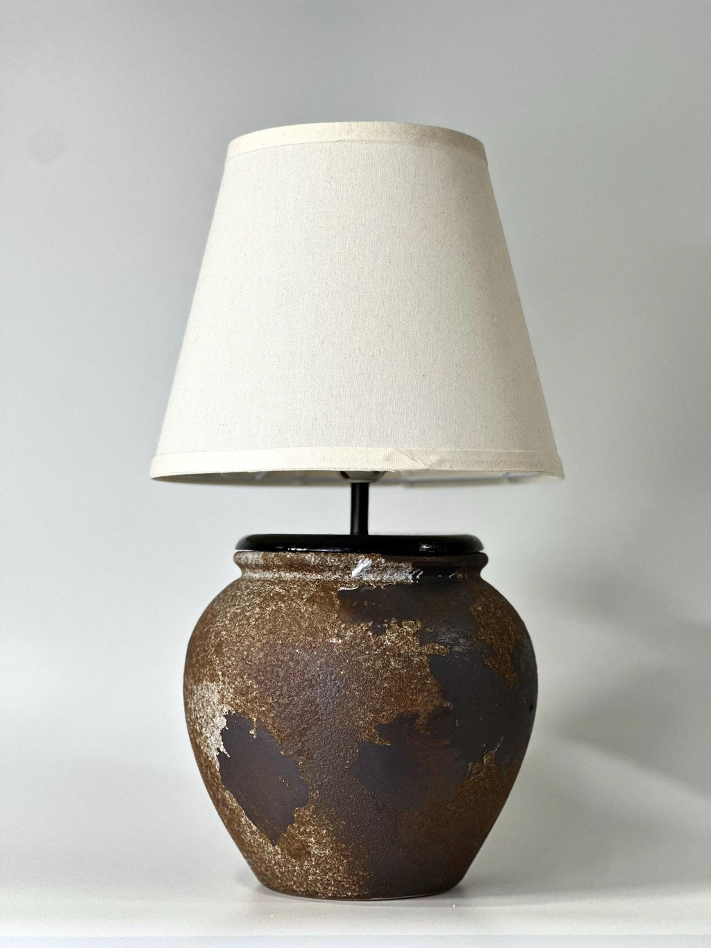 Handcrafted ceramic lamp with an aged earthen texture and timeless patina, paired with a warm linen shade for a soulful wabi-sabi glow.