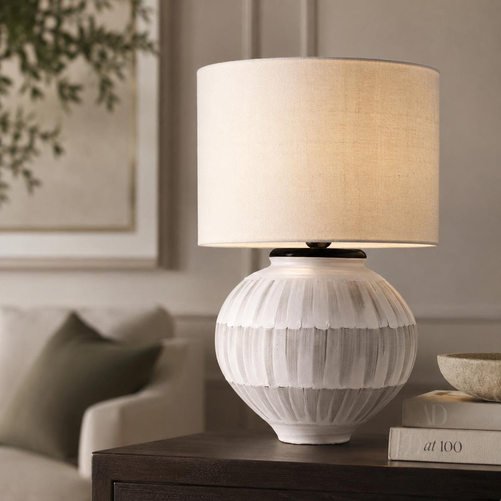 Handmade ceramic table lamp with a hand-painted ceramic body and soft fabric shade, casting a warm wabi-sabi glow.