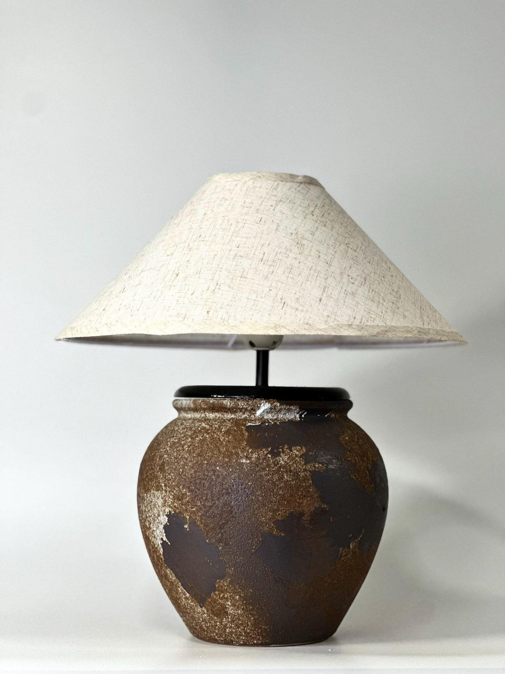 Handcrafted ceramic lamp with an aged earthen texture and timeless patina, paired with a warm linen shade for a soulful wabi-sabi glow.