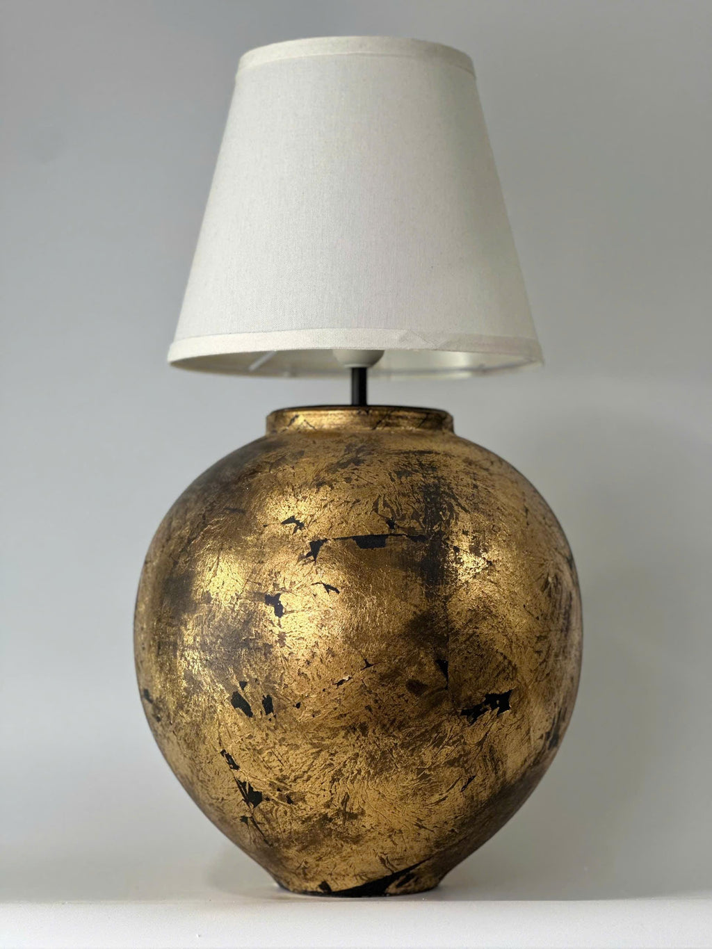 Handmade ceramic table lamp with a vintage gold finish—bringing warm, timeless elegance to any cozy interior.