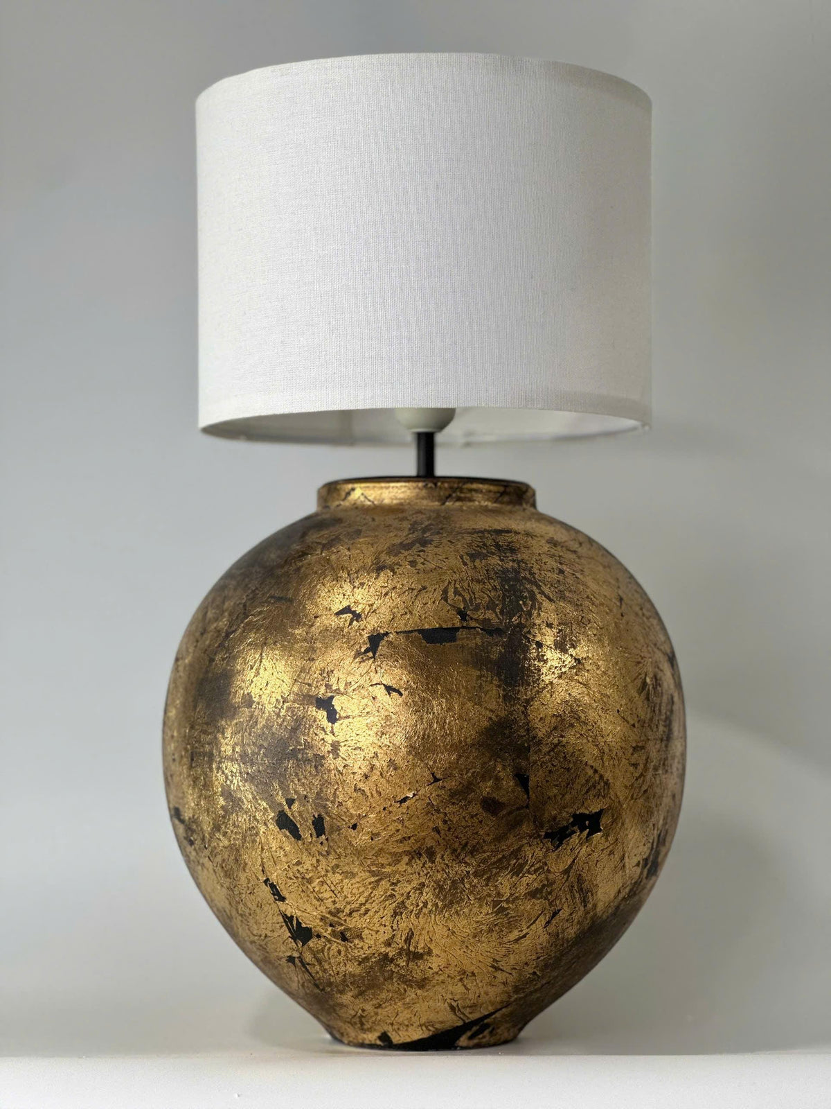 Handmade ceramic table lamp with a vintage gold finish—bringing warm, timeless elegance to any cozy interior.