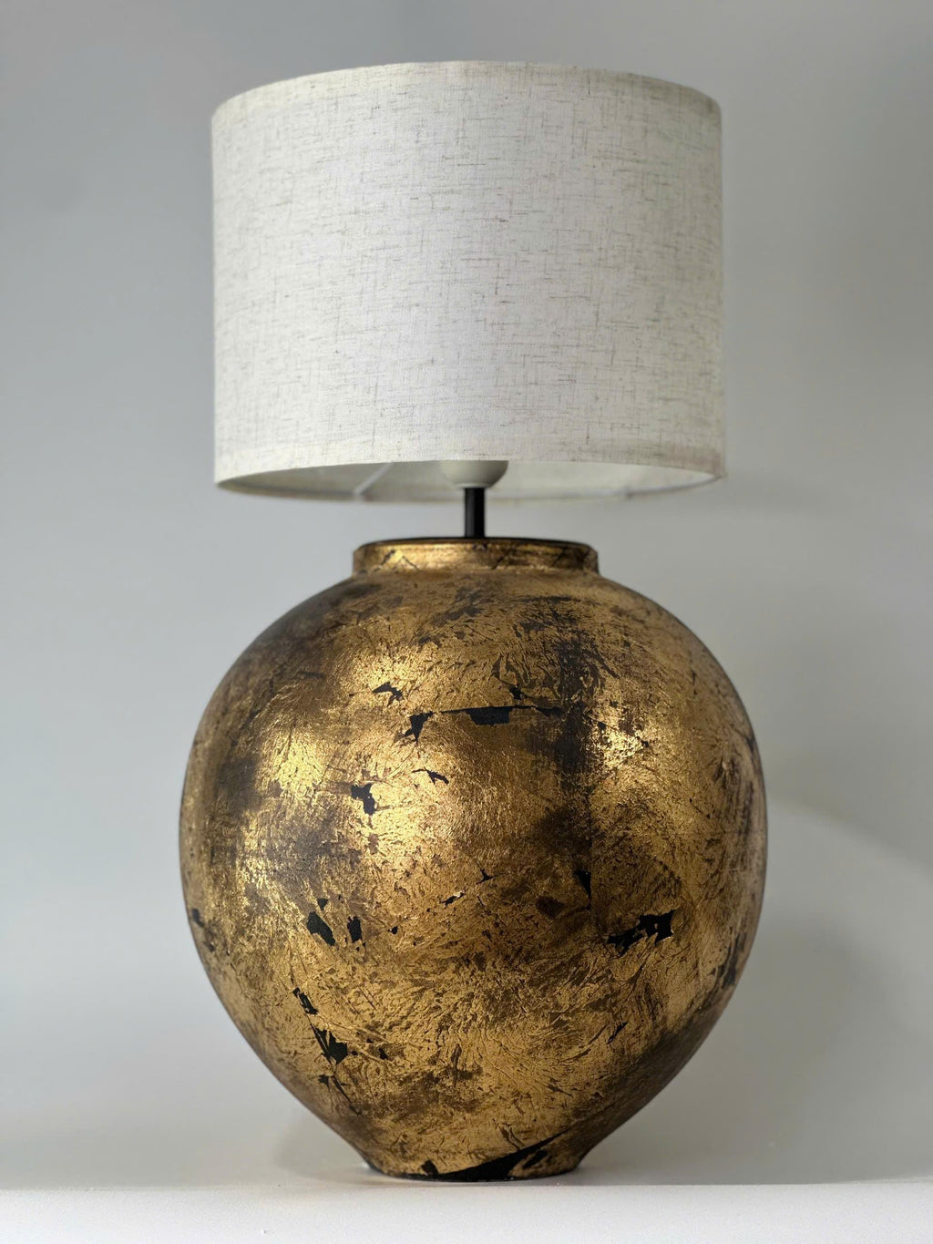 Handmade ceramic table lamp with a vintage gold finish—bringing warm, timeless elegance to any cozy interior.
