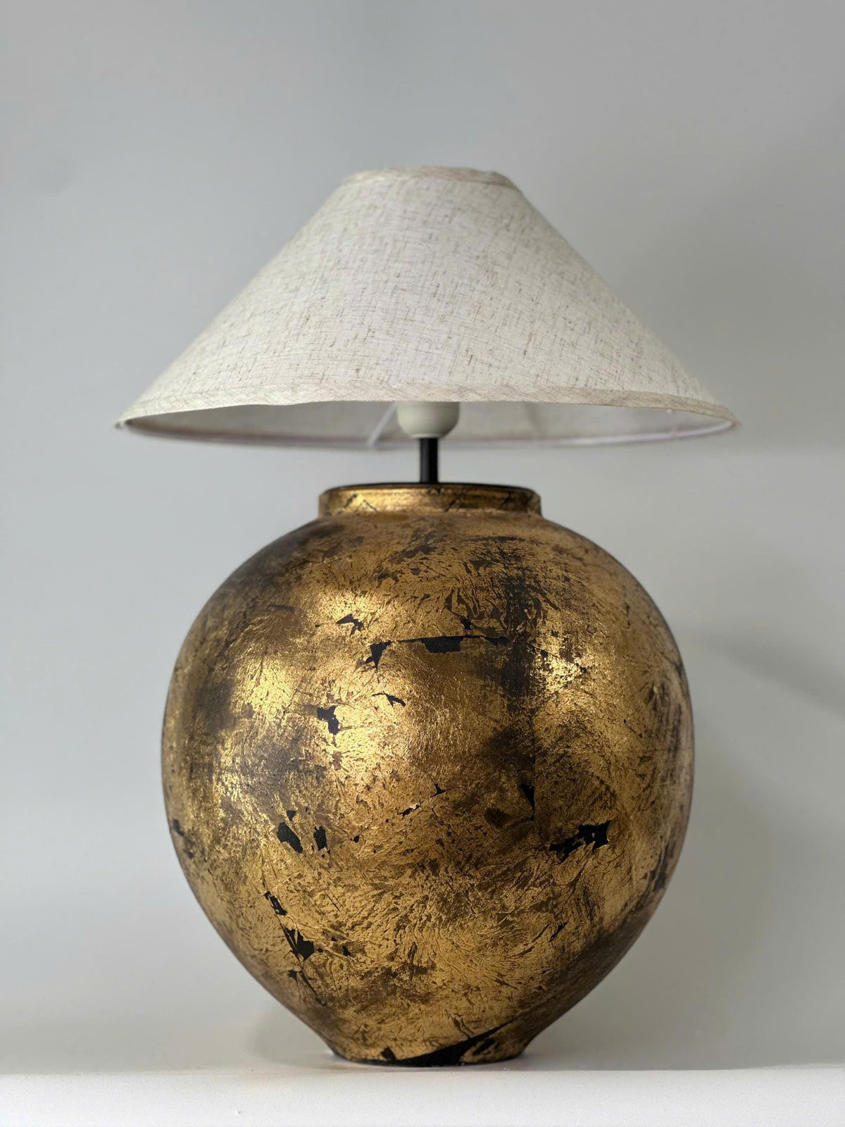 Handmade ceramic table lamp with a vintage gold finish—bringing warm, timeless elegance to any cozy interior.