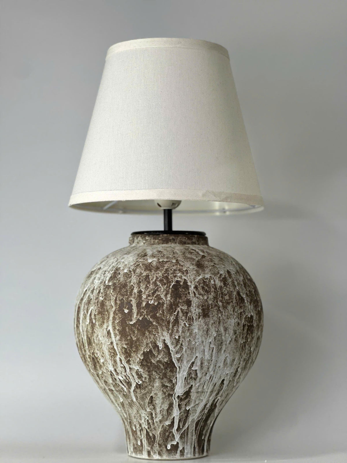 Handcrafted ceramic table lamp with an aged earthy finish, bringing warm wabi-sabi charm and timeless elegance to any space.