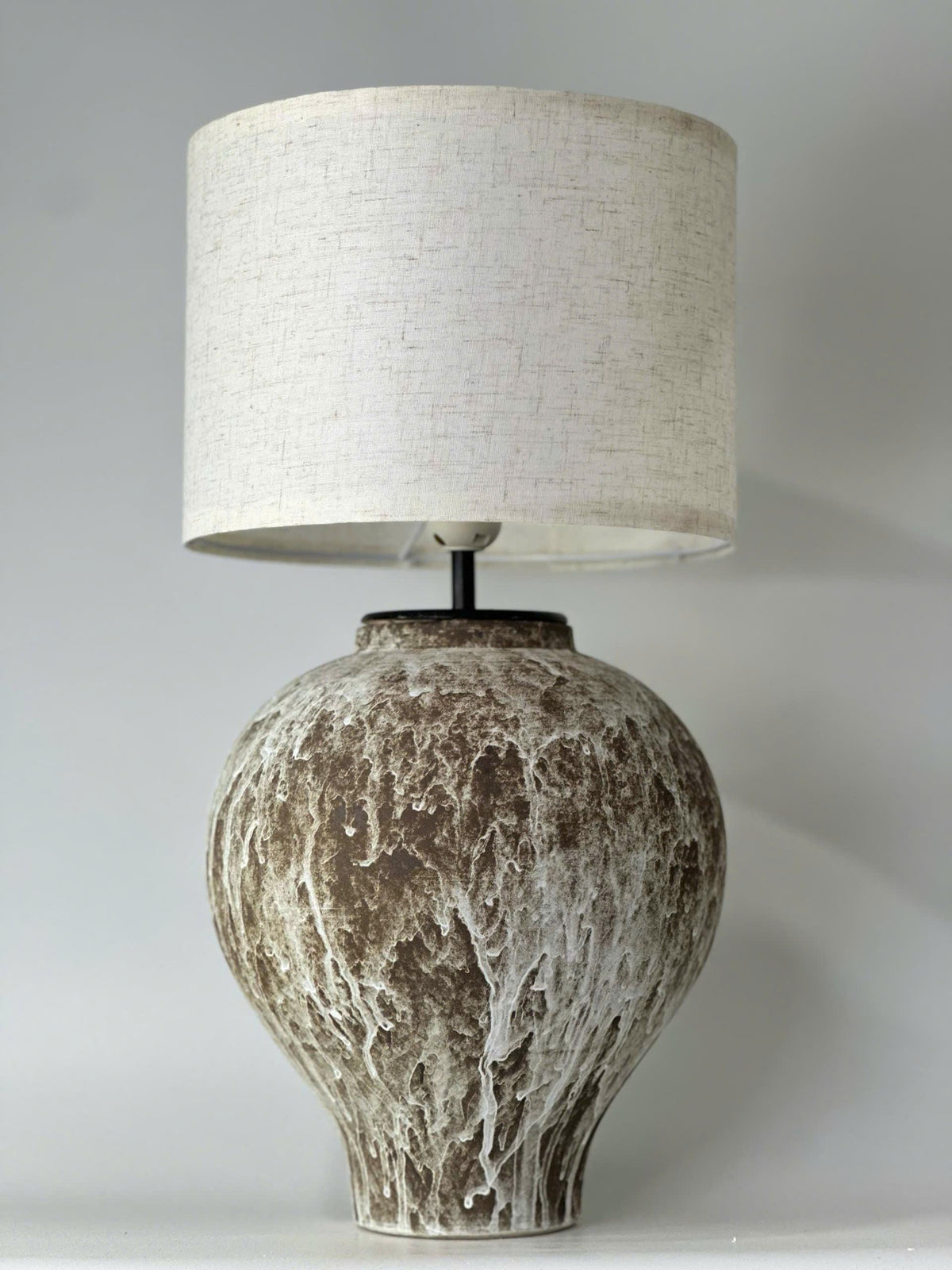 Handcrafted ceramic table lamp with an aged earthy finish, bringing warm wabi-sabi charm and timeless elegance to any space.