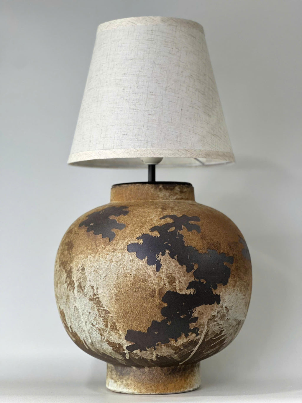 Handcrafted ceramic table lamp with rustic earthy textures, creating a warm, cozy glow for wabi-sabi, Japandi, and modern homes.