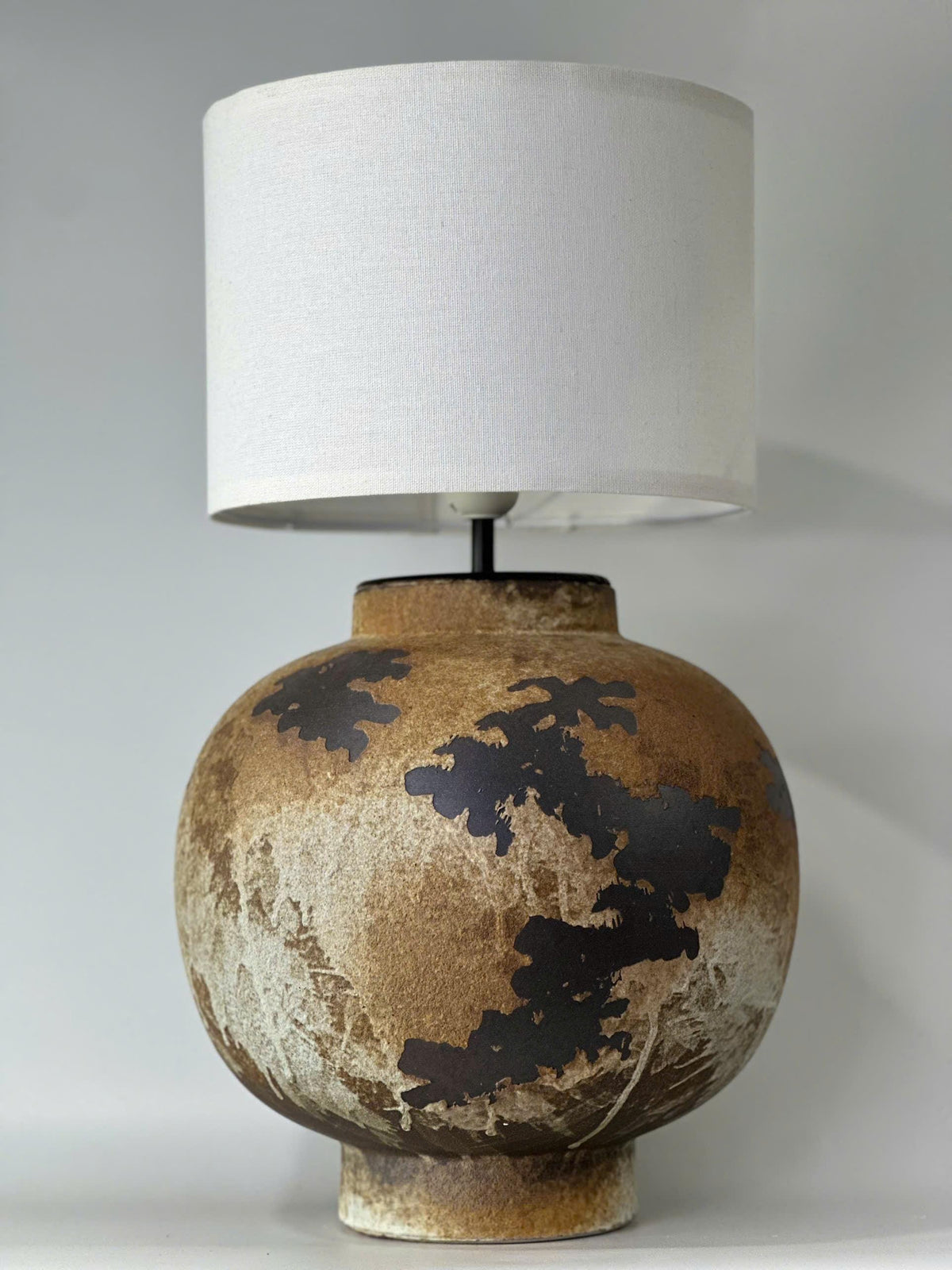 Handcrafted ceramic table lamp with rustic earthy textures, creating a warm, cozy glow for wabi-sabi, Japandi, and modern homes.