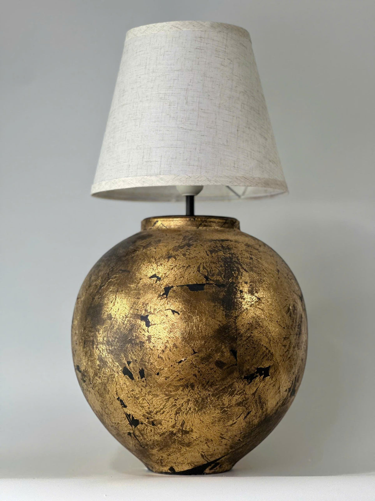 Handmade ceramic table lamp with a vintage gold finish—bringing warm, timeless elegance to any cozy interior.