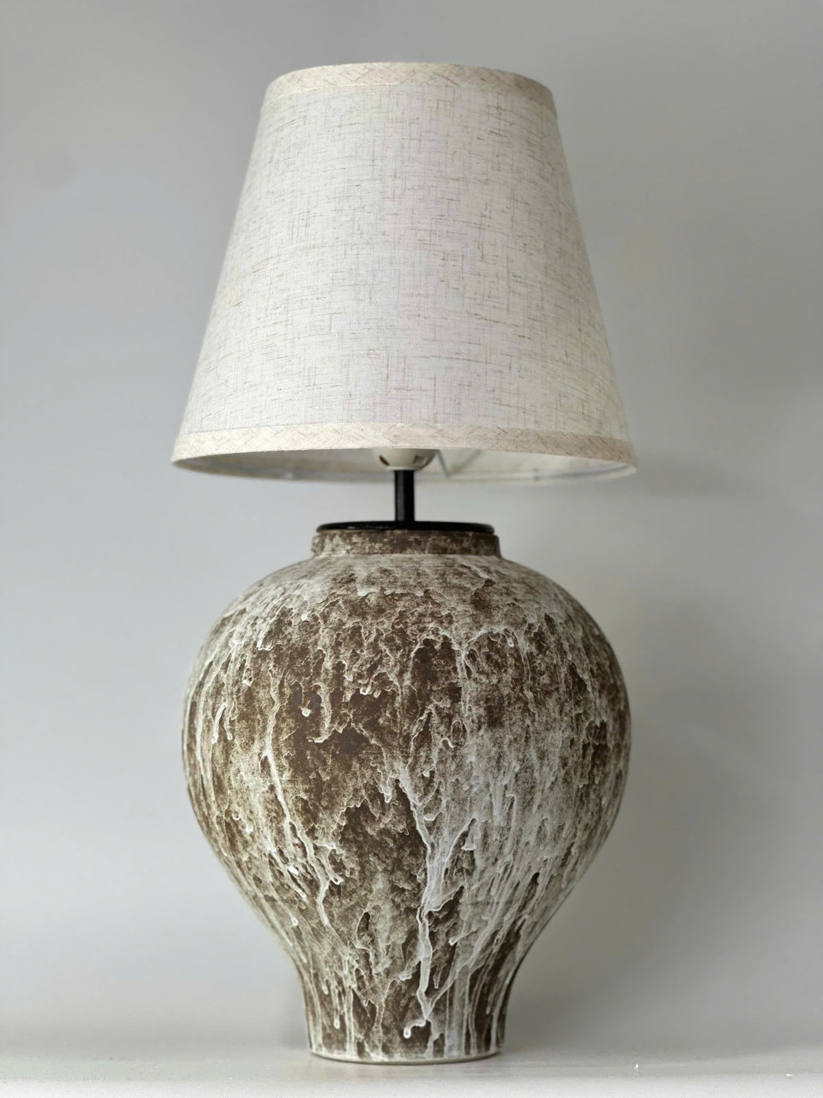 Handcrafted ceramic table lamp with an aged earthy finish, bringing warm wabi-sabi charm and timeless elegance to any space.