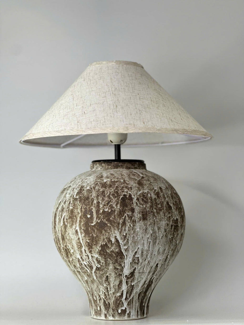 Handcrafted ceramic table lamp with an aged earthy finish, bringing warm wabi-sabi charm and timeless elegance to any space.