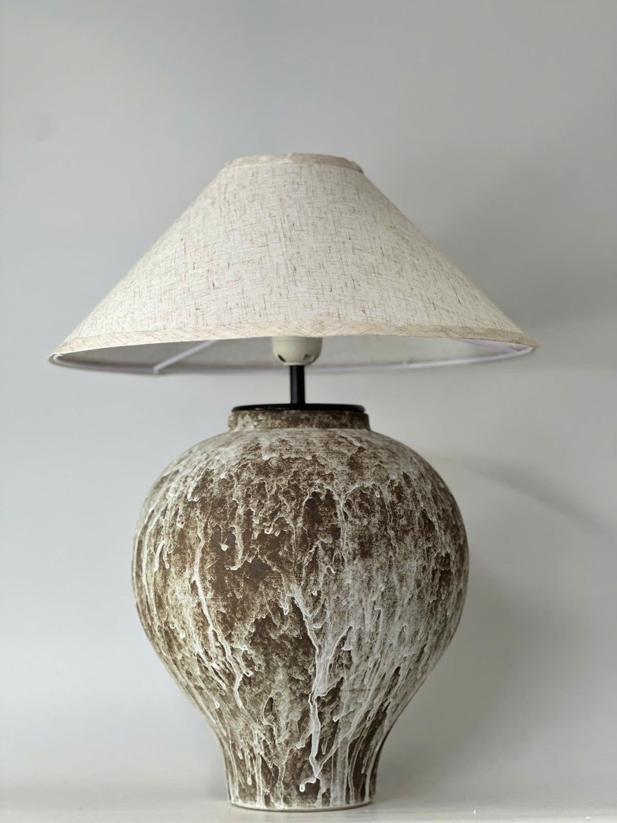 Handcrafted ceramic table lamp with an aged earthy finish, bringing warm wabi-sabi charm and timeless elegance to any space.
