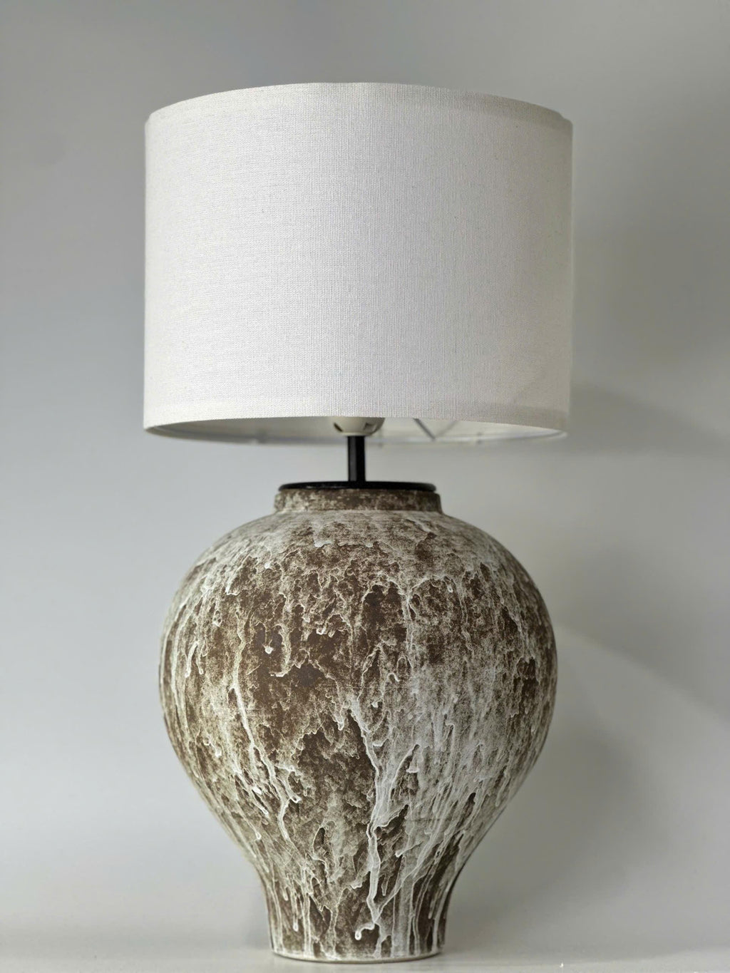 Handcrafted ceramic table lamp with an aged earthy finish, bringing warm wabi-sabi charm and timeless elegance to any space.