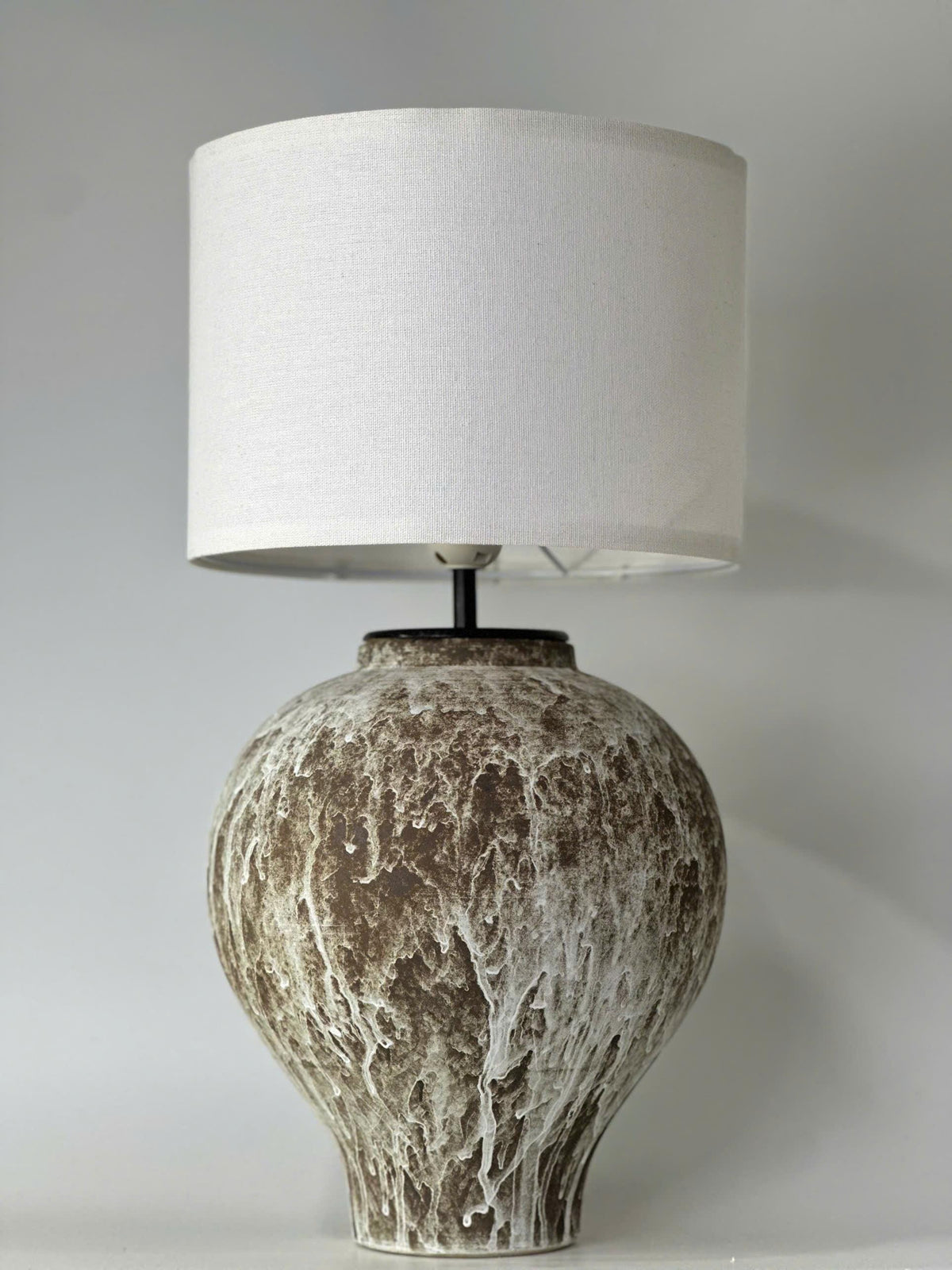 Handcrafted ceramic table lamp with an aged earthy finish, bringing warm wabi-sabi charm and timeless elegance to any space.