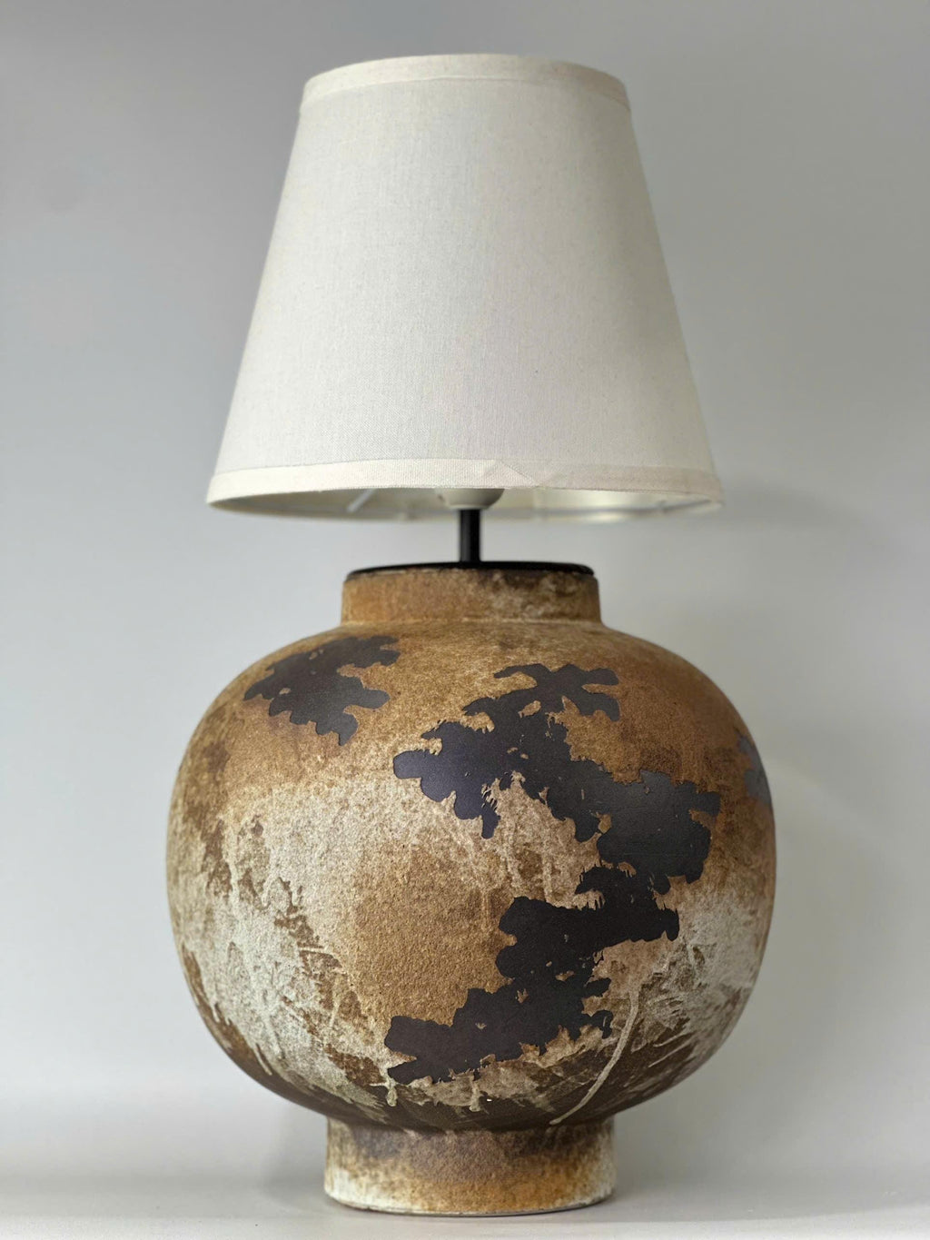 Handcrafted ceramic table lamp with rustic earthy textures, creating a warm, cozy glow for wabi-sabi, Japandi, and modern homes.