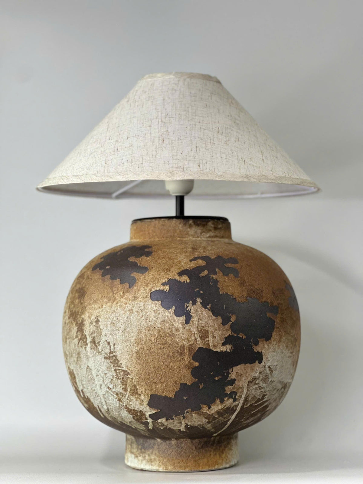 Handcrafted ceramic table lamp with rustic earthy textures, creating a warm, cozy glow for wabi-sabi, Japandi, and modern homes.