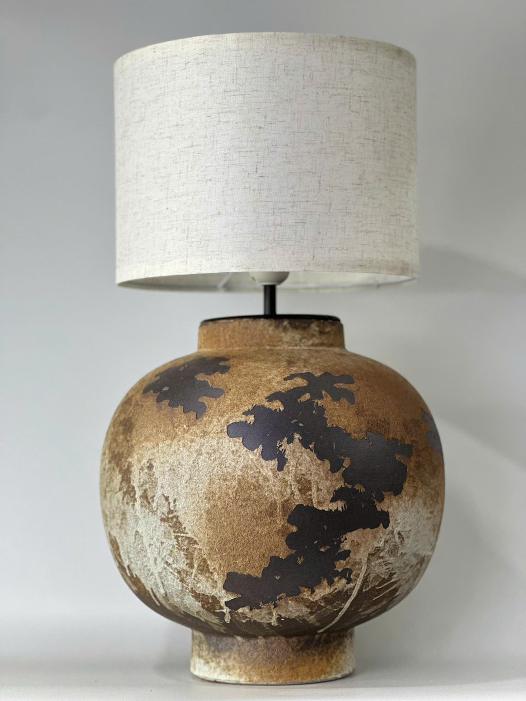 Handcrafted ceramic table lamp with rustic earthy textures, creating a warm, cozy glow for wabi-sabi, Japandi, and modern homes.