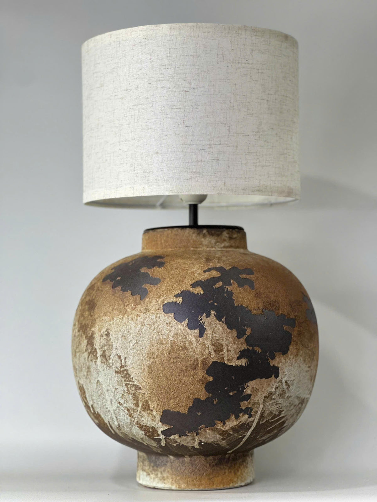 Handcrafted ceramic table lamp with rustic earthy textures, creating a warm, cozy glow for wabi-sabi, Japandi, and modern homes.