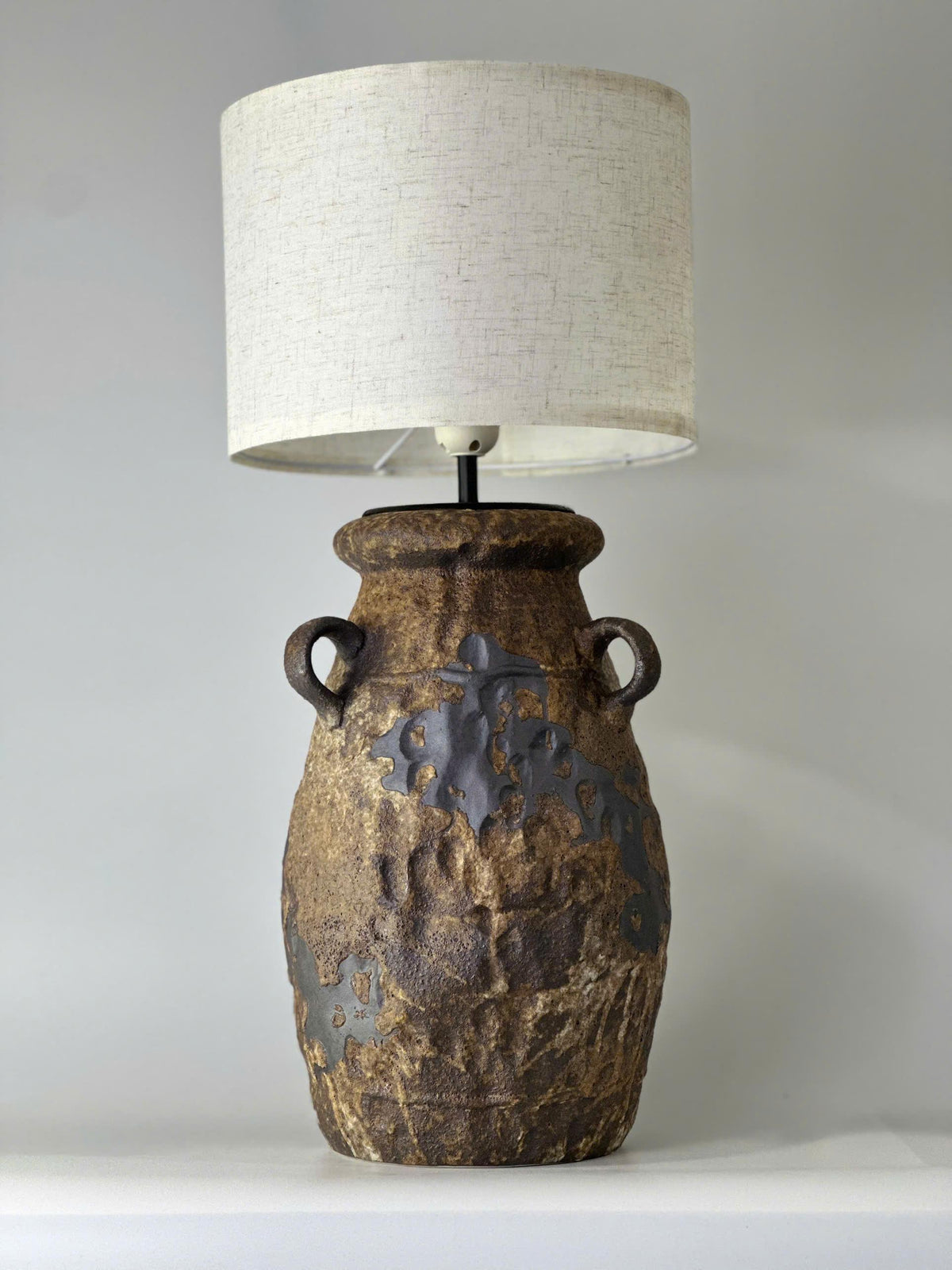 Handcrafted ceramic table lamp with rustic earthy textures, creating a warm, cozy glow for wabi-sabi, Japandi, and modern homes.