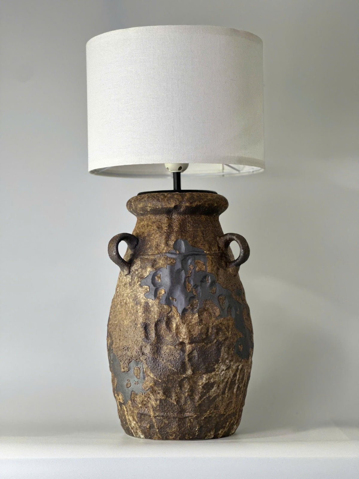 Handcrafted ceramic table lamp with rustic earthy textures, creating a warm, cozy glow for wabi-sabi, Japandi, and modern homes.