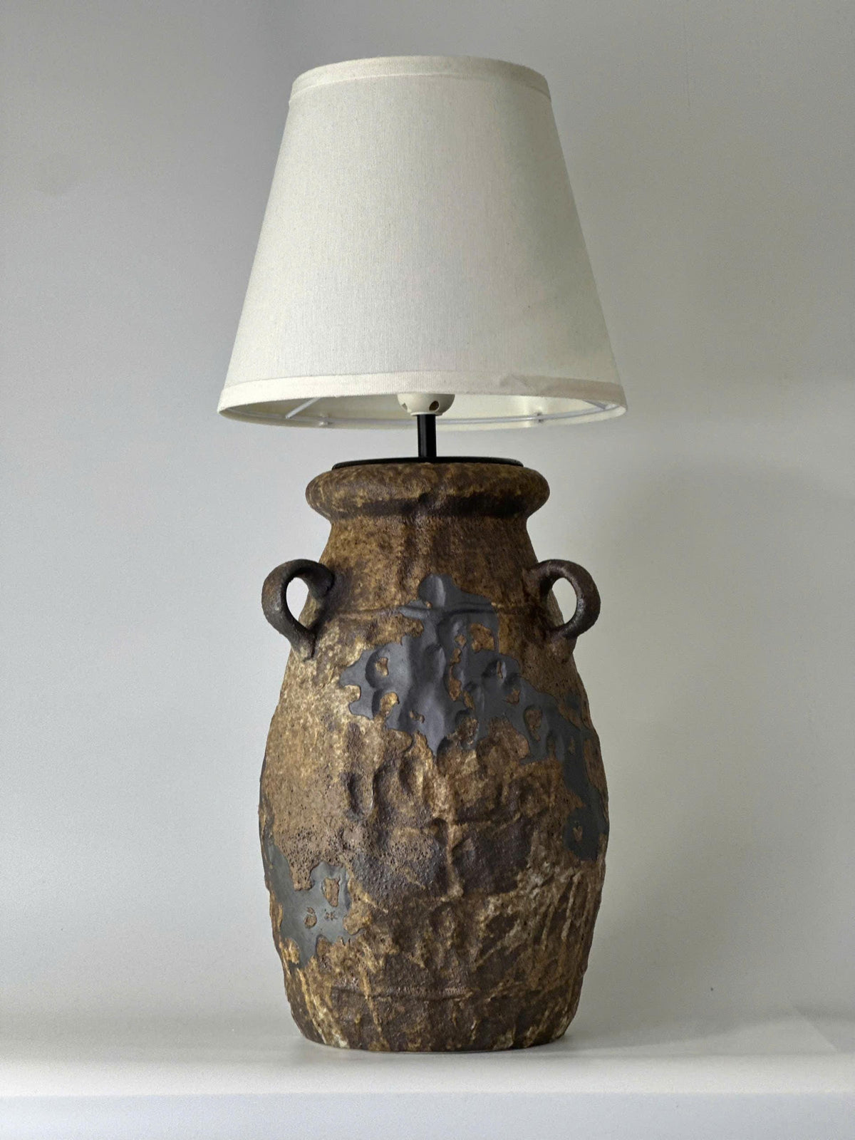 Handcrafted ceramic table lamp with rustic earthy textures, creating a warm, cozy glow for wabi-sabi, Japandi, and modern homes.